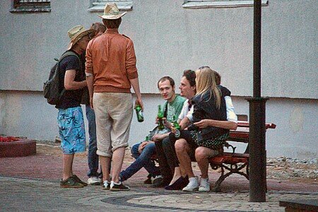 Маладыя людзі распіваюць піва побач з Кастрычніцім РАУС. Фота Сержука Серабро